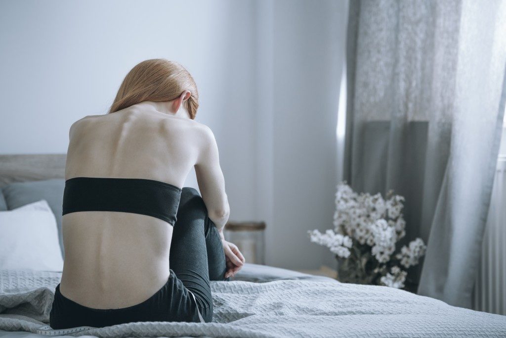 woman in bed suffering from anorexia