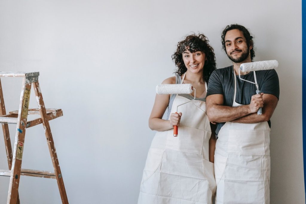 couple holding paint rollers