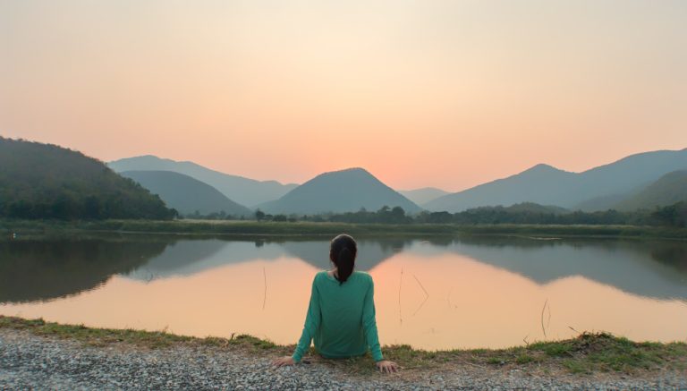 traveler woman relaxing beside a lake