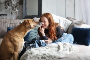 beautiful redhead woman spending time with dog at home