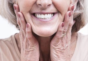 An elderly woman showing a good set of teeth