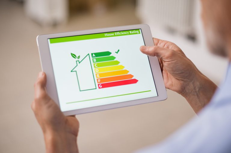 person holding a tablet with home energy efficiency rating