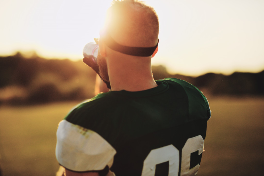 Shot of a football players back while drinking water