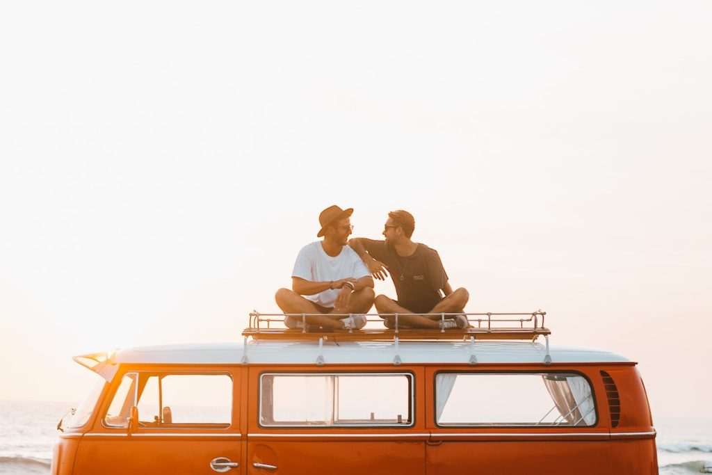 Happy friends on camper van roof