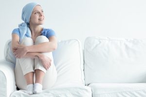 A woman with cancer sitting on a couch