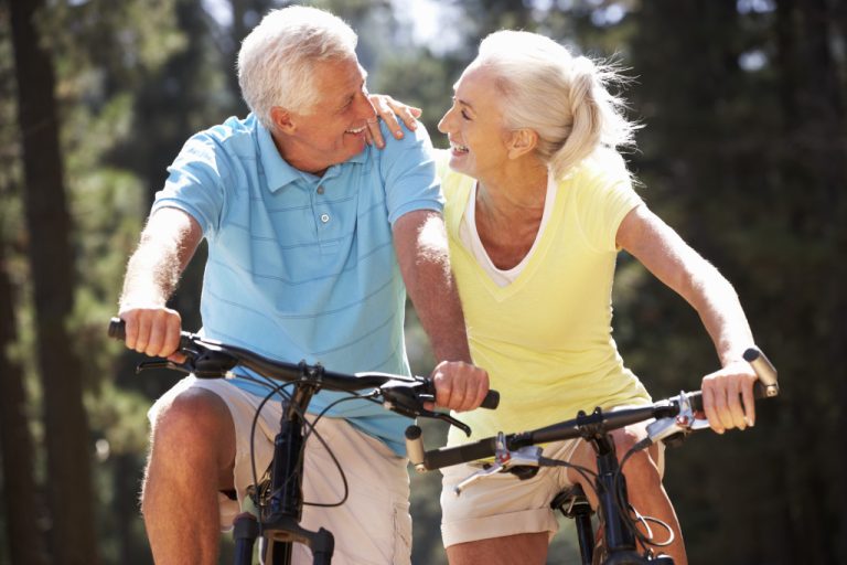 elderly couple enjoying biking outside together