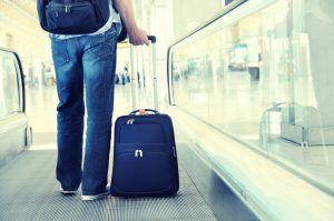 A traveler with a suitcase on an airport speedwalk